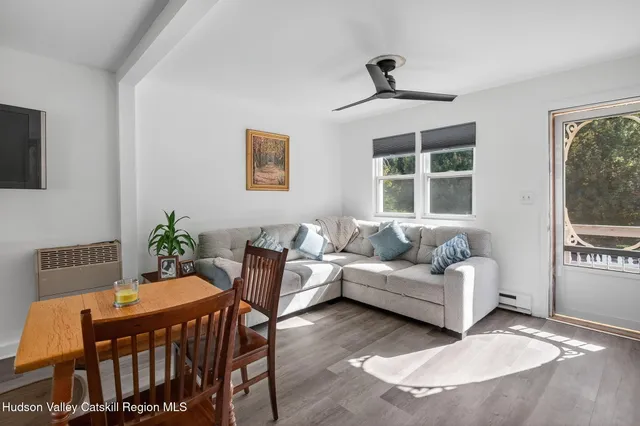 a dining room with furniture potted plants and wooden floor