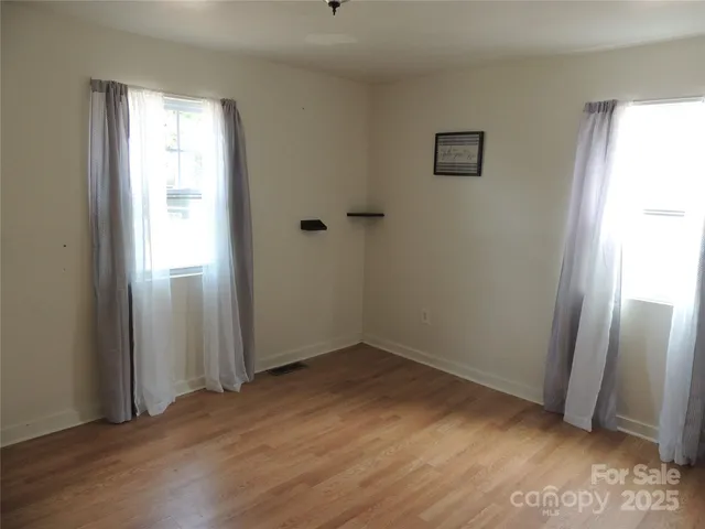 an empty room with wooden floor and a window
