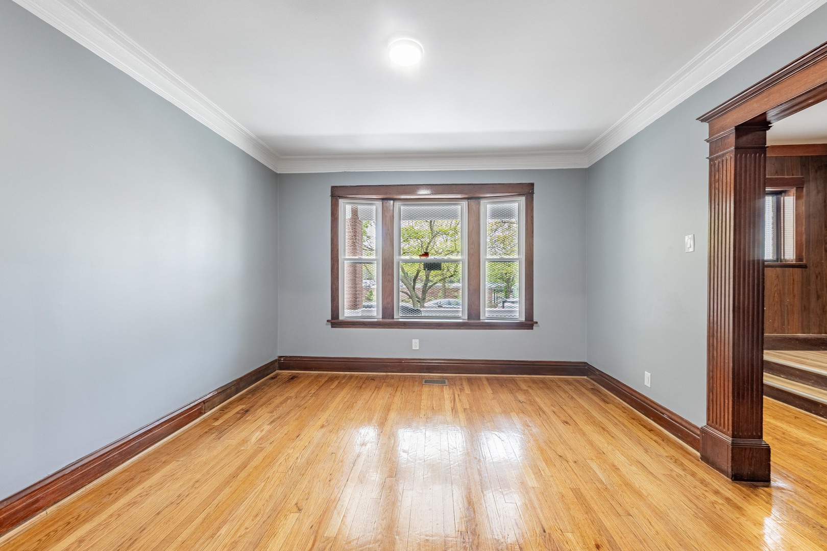 7629 South Green Street Chicago, IL 60620 - Photo 11 of 53 an empty room with wooden floor and windows