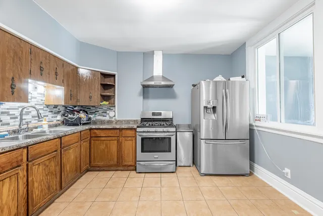 a kitchen with stainless steel appliances granite countertop a refrigerator sink and cabinets
