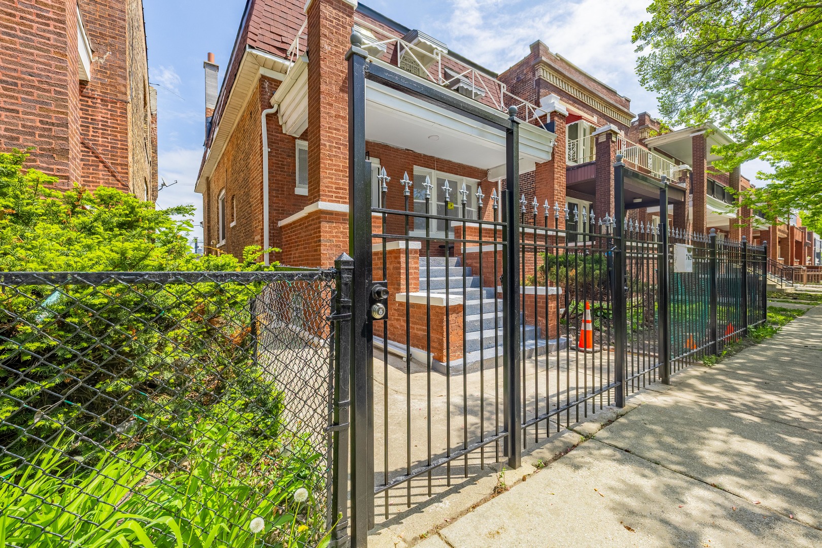 7629 South Green Street Chicago, IL 60620 - Photo 2 of 53 a view of a brick house with a large window and plants