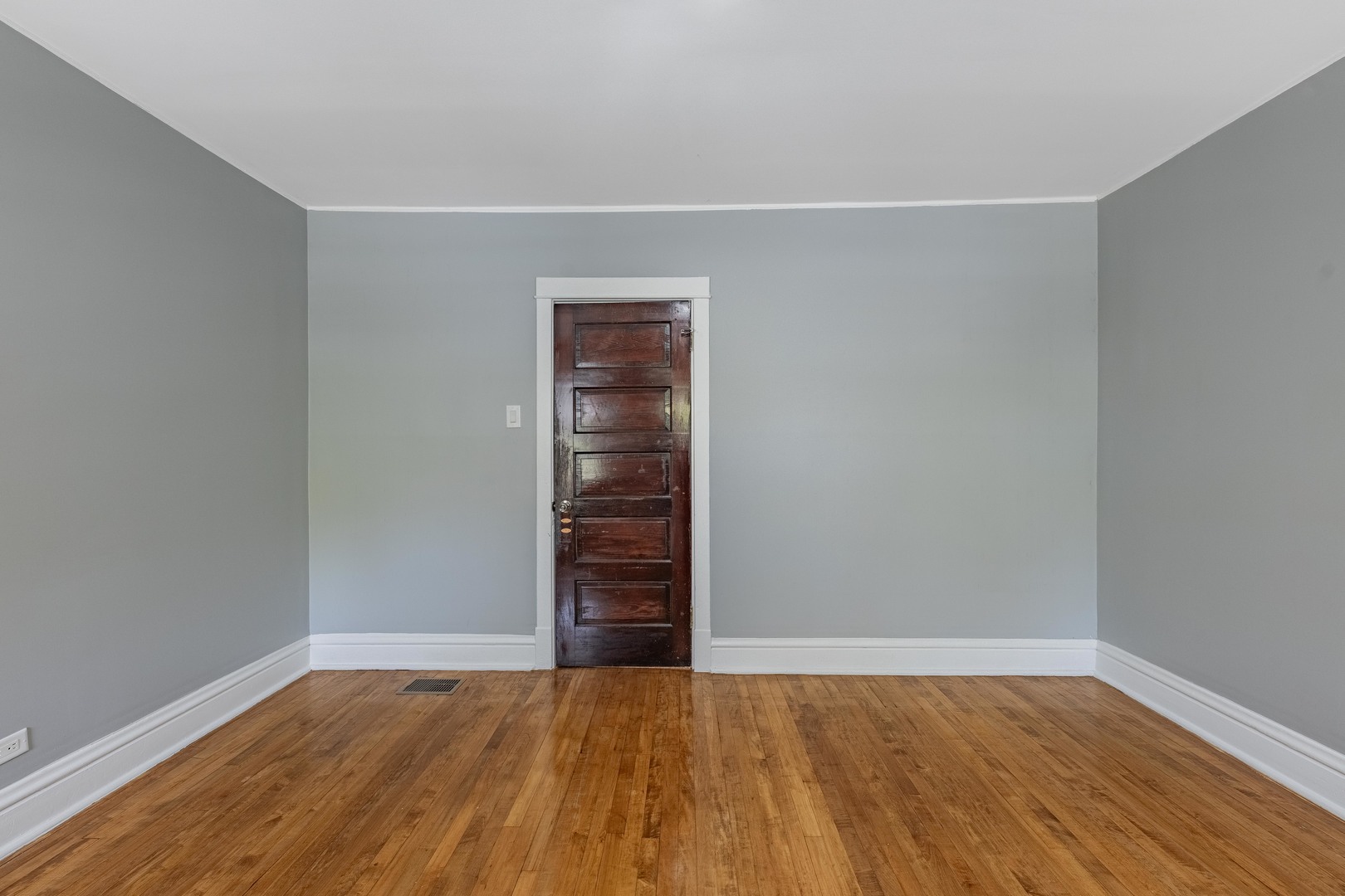7629 South Green Street Chicago, IL 60620 - Photo 21 of 53 a view of an empty room with wooden floor and a window