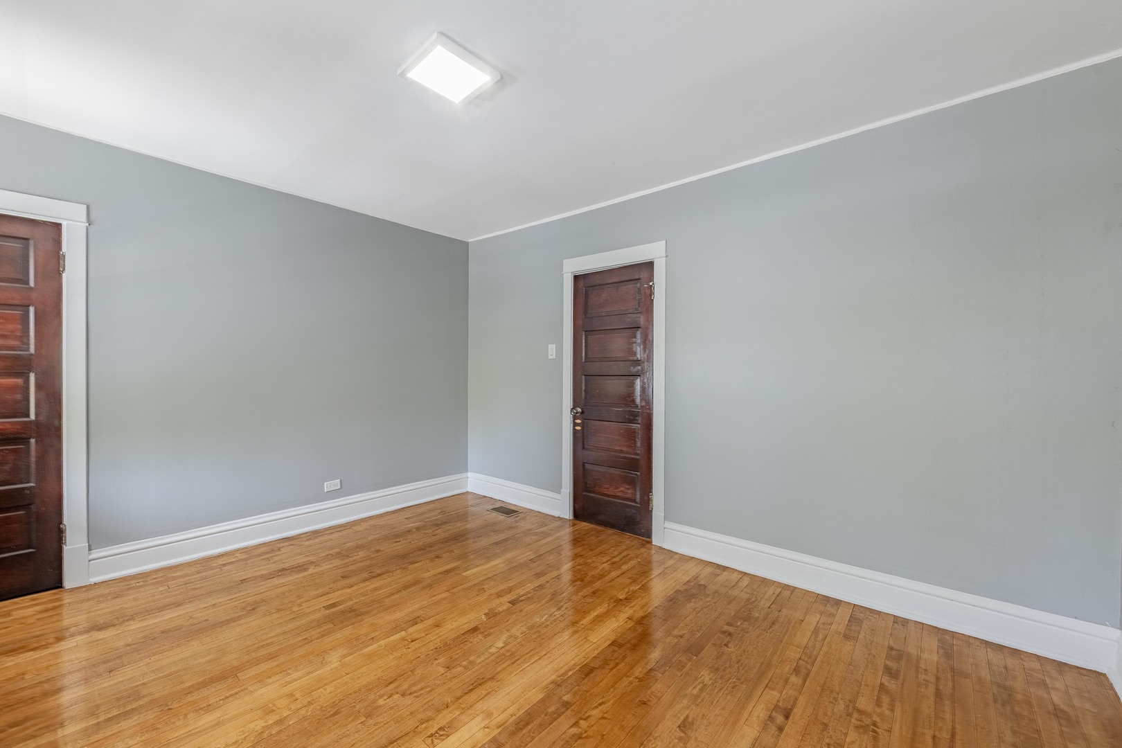7629 South Green Street Chicago, IL 60620 - Photo 22 of 53 an empty room with wooden floor and windows