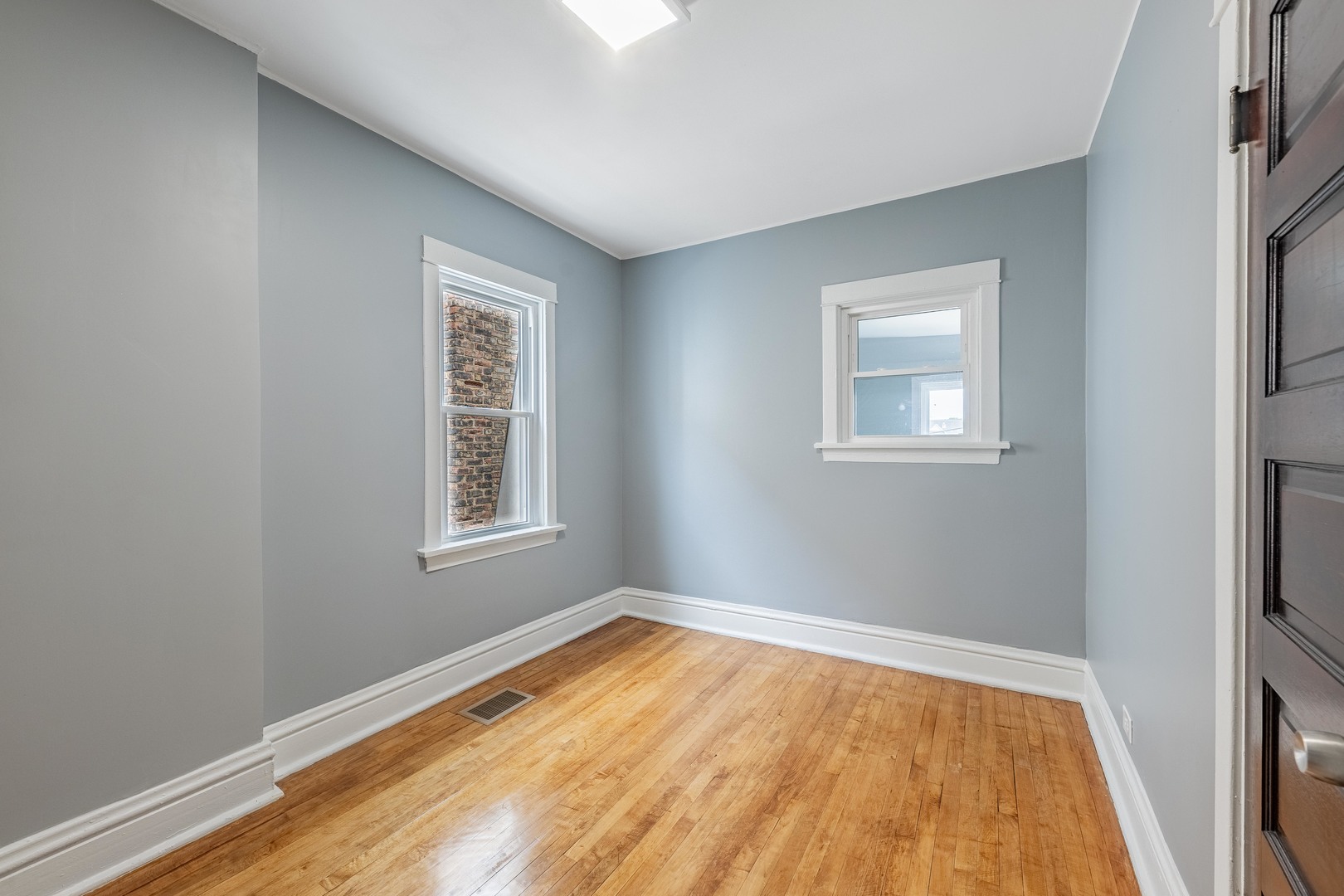 7629 South Green Street Chicago, IL 60620 - Photo 29 of 53 a view of an empty room with wooden floor and a window