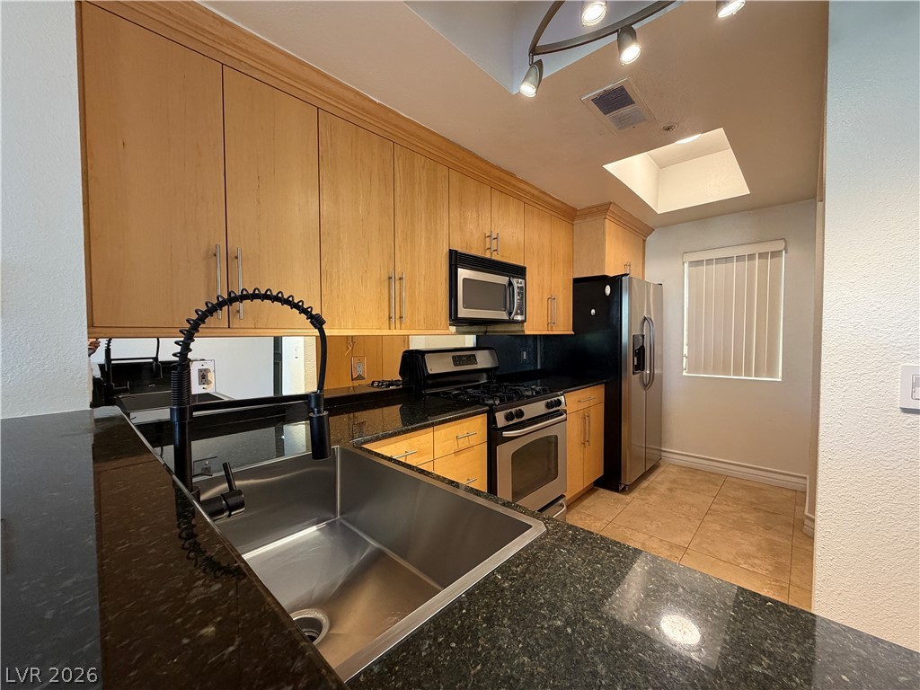 210 East Flamingo Road, Unit 126 Las Vegas, NV 89169 - Photo 4 of 16 Culinary aspirations find their home in this well-appointed kitchen featuring sleek granite counters and natural light.