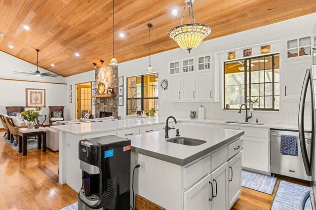 a bathroom with a double vanity sink a mirror and a bathtub next to a window