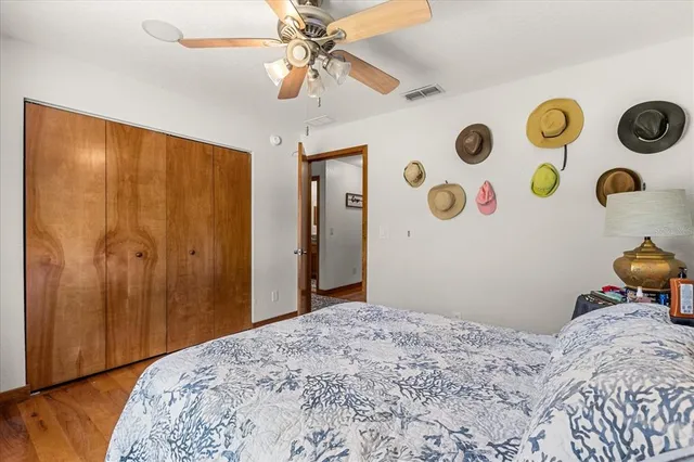 a view of a roof deck with table and chairs under an umbrella with large trees