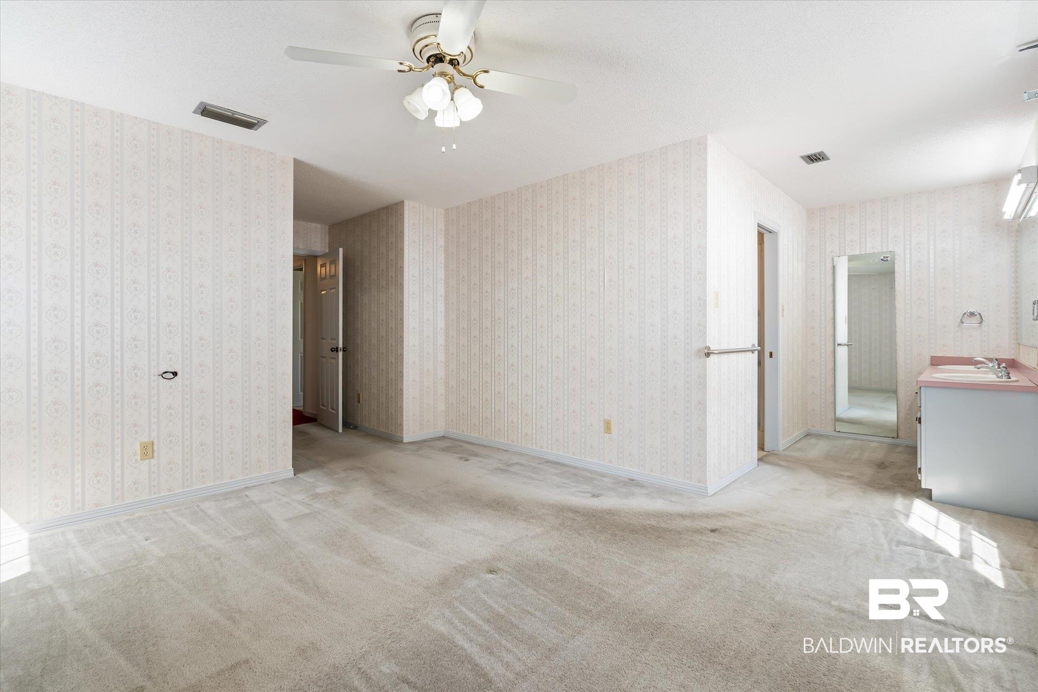 6030 Lott Road Eight Mile, AL 36613 - Photo 10 of 21 Carpeted spare room with wallpapered walls, visible vents, ceiling fan, and a sink