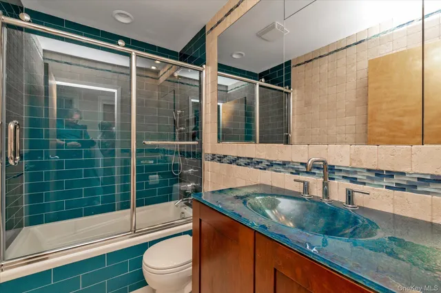 a bathroom with a granite countertop sink toilet and shower