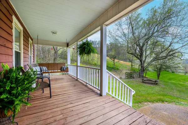 a dining room with wooden floor a chandelier a glass table and chairs