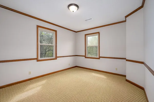 a front view of house with yard and trees in the background