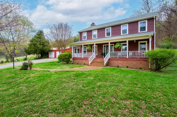 a view of a porch with wooden floor next to a yard