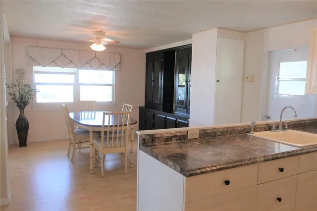 a kitchen with granite countertop sink table and chairs