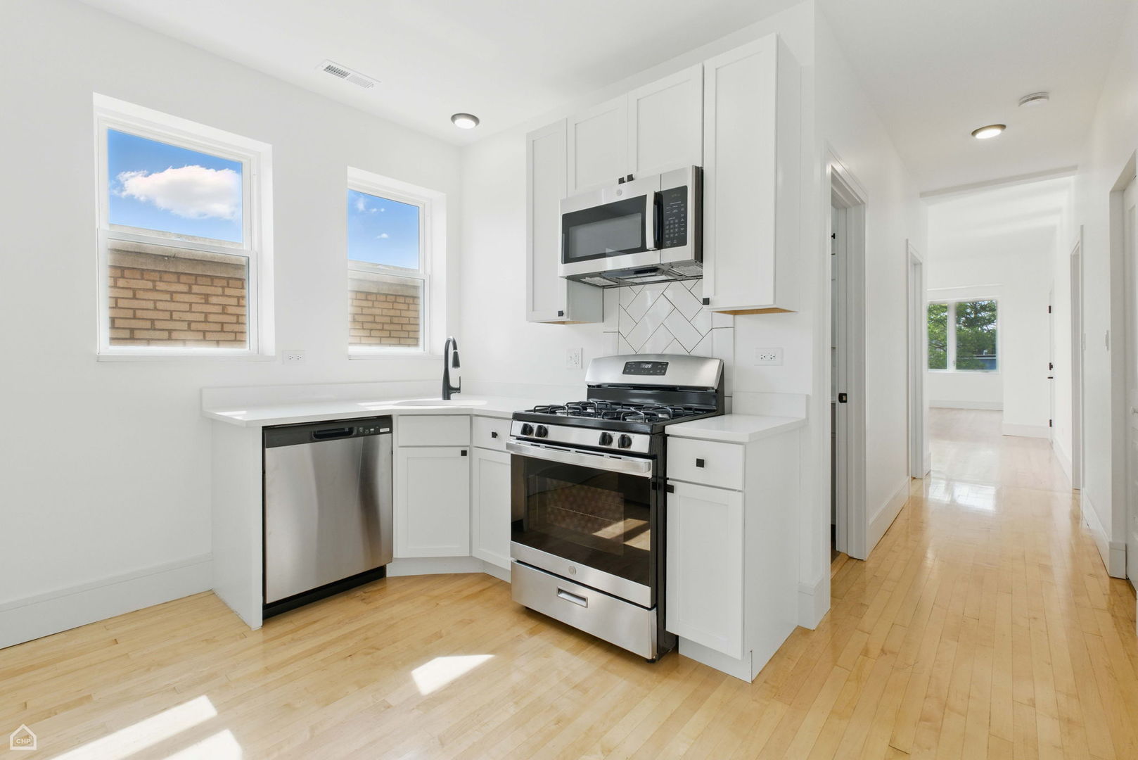 1928 West 21st Street, Unit 2F Chicago, IL 60608 - Photo 6 of 16 a kitchen with stainless steel appliances white cabinets a sink and a stove