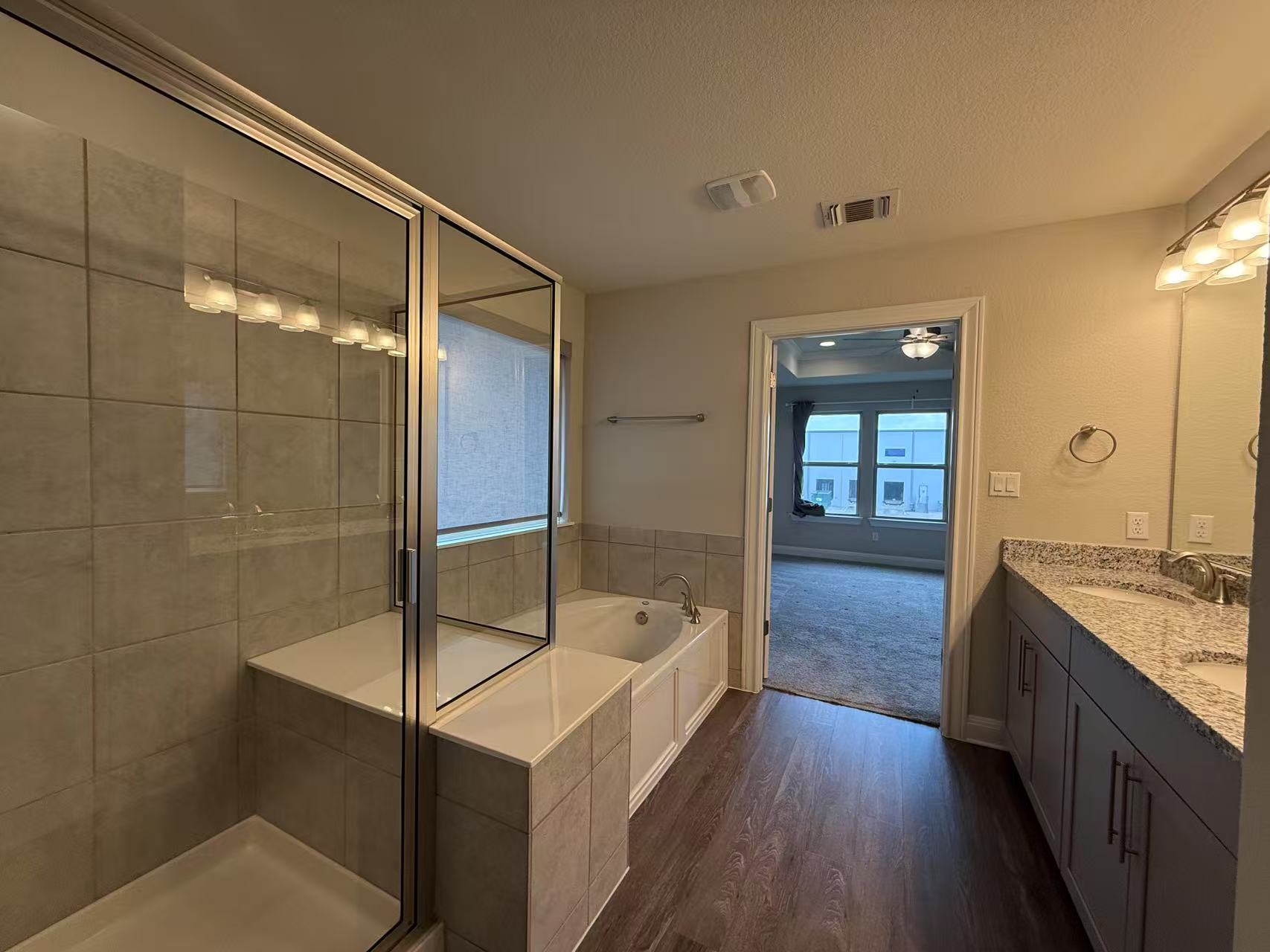 16103 Windroot Street Austin, TX 78728 - Photo 20 of 32 Bathroom with a sink, a shower stall, wood finished floors, visible vents, and a bath