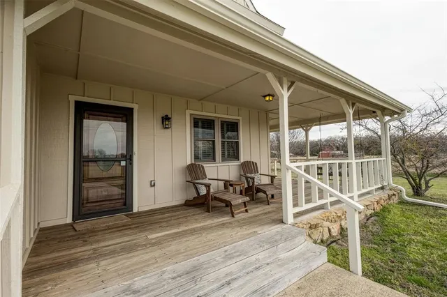 a view of a house with wooden deck and furniture