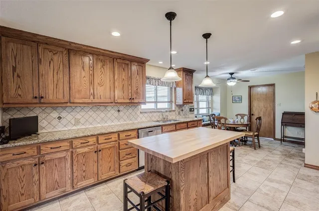 a kitchen with a cabinets a center island a dining table and chairs