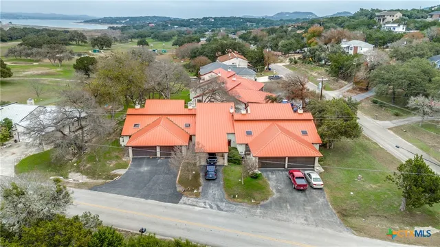 an aerial view of residential houses with outdoor space and swimming pool