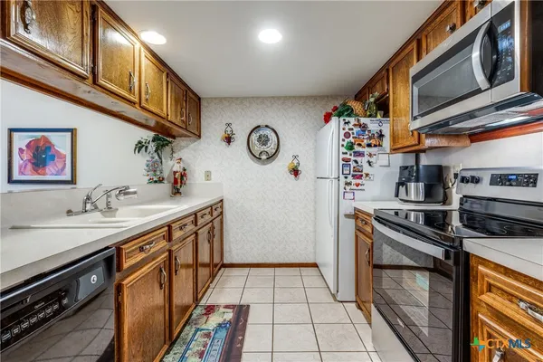 a kitchen with stainless steel appliances a sink and cabinets