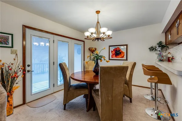 a view of a dining room with furniture and chandelier