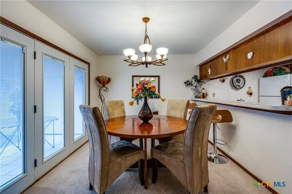 a view of a dining room with furniture and chandelier