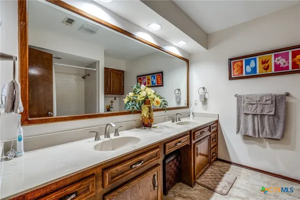 a bathroom with a sink double vanity granite and a mirror