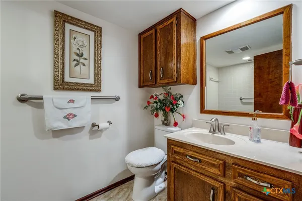a bathroom with a granite countertop sink mirror vanity and toilet