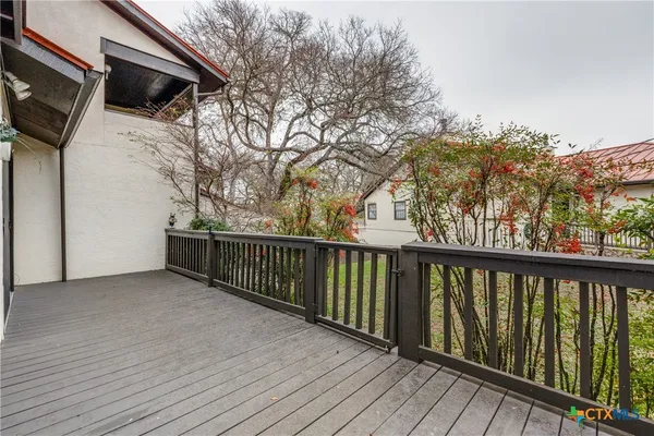 a view of a porch with wooden floor and fence