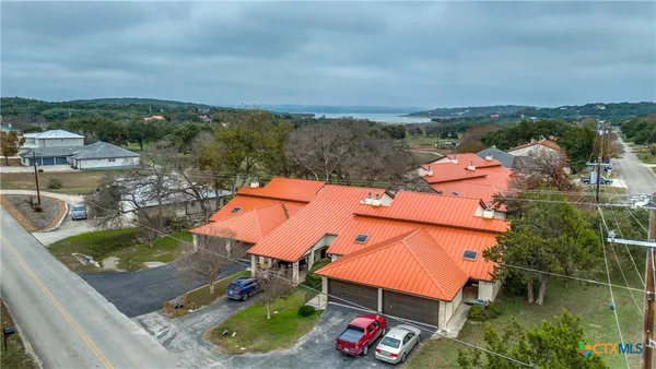 an aerial view of a house with a garden and lake view