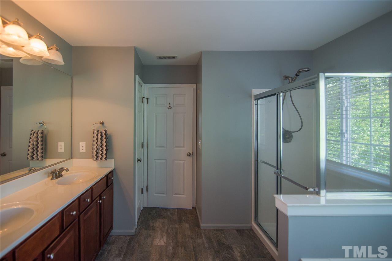 10715 Friendly Neighbor Lane Raleigh, NC 27614 - Photo 14 of 25 Master bathroom offers double sinks and gorgeous, natural timber ash, wood-look tile.