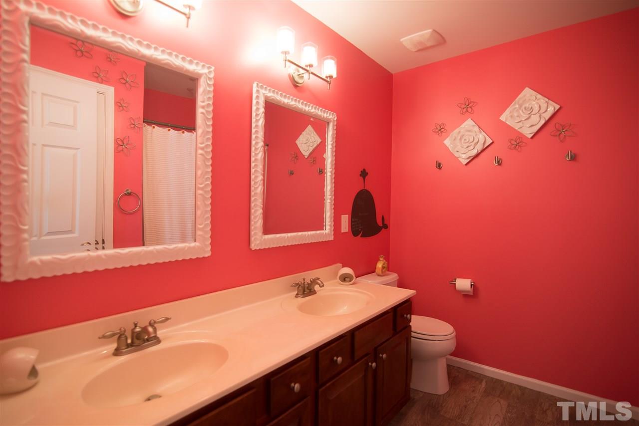 10715 Friendly Neighbor Lane Raleigh, NC 27614 - Photo 19 of 25 Upstairs bathroom features not only fabulous faux wood tile but also dual sinks with decorative dual vanity mirrors!