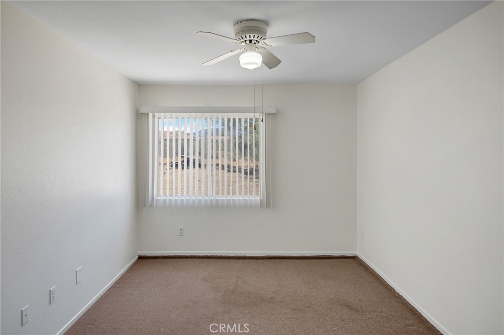 12736 Oasis Road Pinon Hills, CA 92372 - Photo 15 of 33 an empty room with a window and a ceiling fan