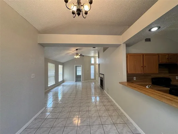 a view of a livingroom with a chandelier fan and windows