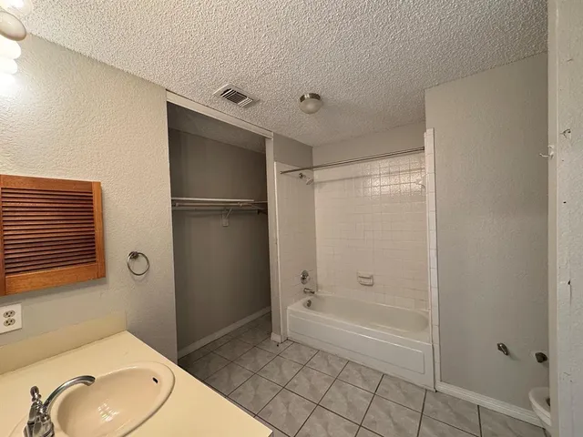 a bathroom with a granite countertop sink mirror and shower