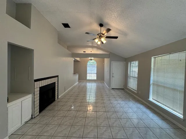 a view of a hallway with a chandelier fan and windows