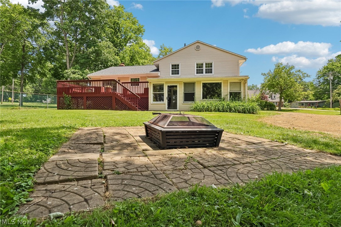 1638 South Cleveland Massillon Road Akron, OH 44321 - Photo 32 of 37 Expansive backyard featuring a patterned paver patio, a freestanding fire pit, and a multi-level wood deck with lattice skirting