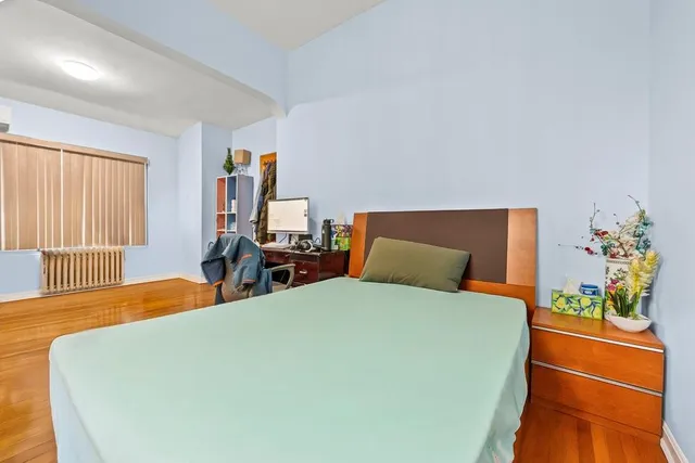 a bedroom with a large bed and a potted plant