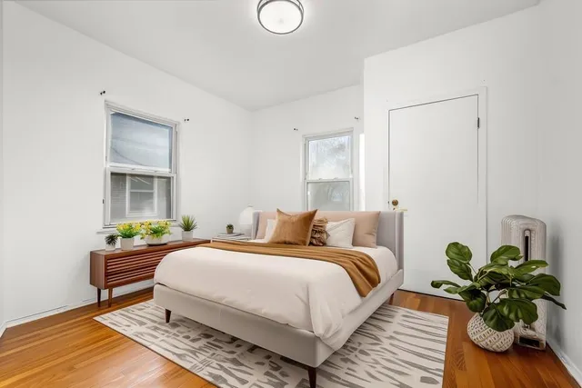 a bedroom with a bed and a potted plant