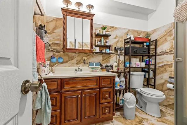 a bathroom with a toilet sink and mirror