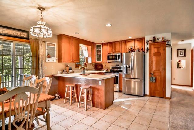 5901 Rotary Road Cherry Valley, IL 61016 - Photo 5 of 19 a kitchen with stainless steel appliances a refrigerator a stove a sink dishwasher a dining table and chairs with wooden floor