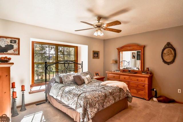5901 Rotary Road Cherry Valley, IL 61016 - Photo 8 of 19 a bedroom with a large bed and a chandelier