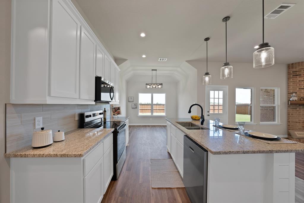 113 Panther Loop Mabank, TX 75147 - Photo 4 of 15 a kitchen with granite countertop a sink a counter space appliances and cabinets