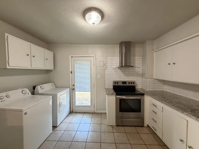 a kitchen with a stove sink and cabinets