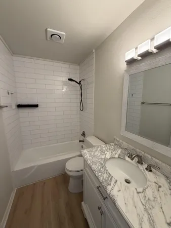 a bathroom with a granite countertop sink toilet and shower