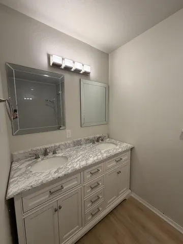 a bathroom with a granite countertop sink and a mirror
