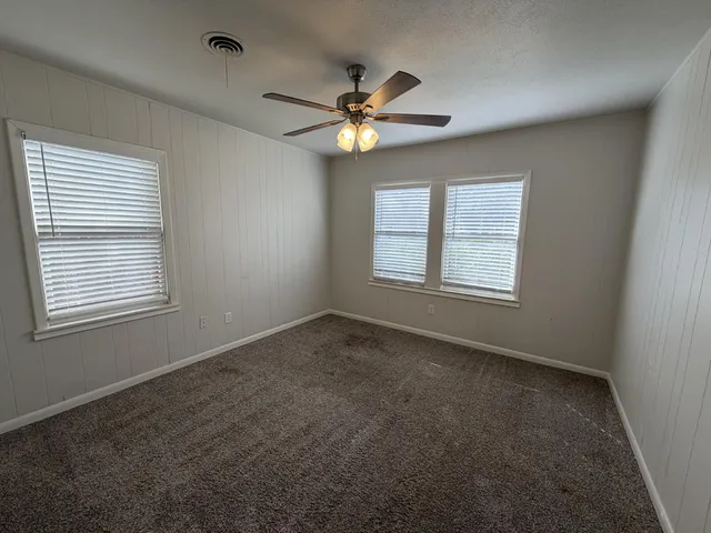 a view of a livingroom with a ceiling fan and window