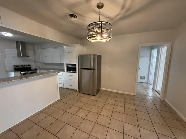 a kitchen with stainless steel appliances granite countertop a refrigerator and a stove top oven