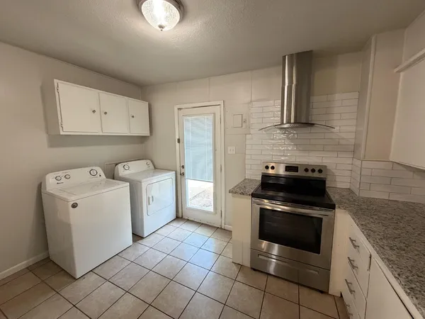 a kitchen with a stove top oven and cabinets
