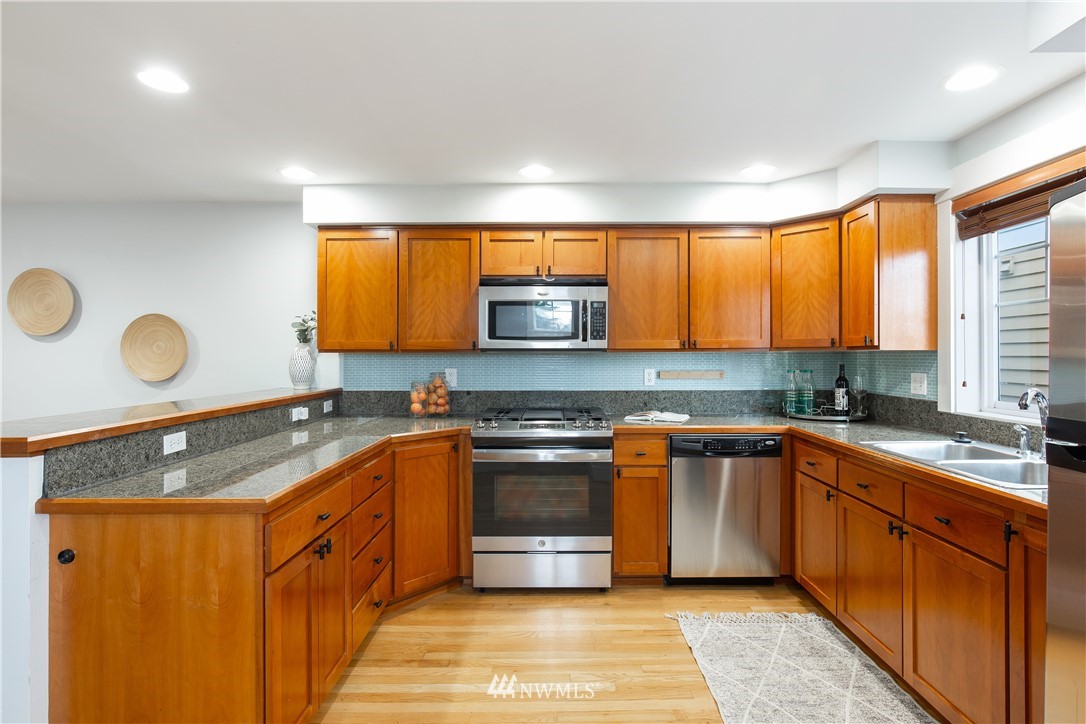 10303 Holman Road North, Unit A Seattle, WA 98177 - Photo 15 of 40 a kitchen with stainless steel appliances granite countertop a sink and a stove