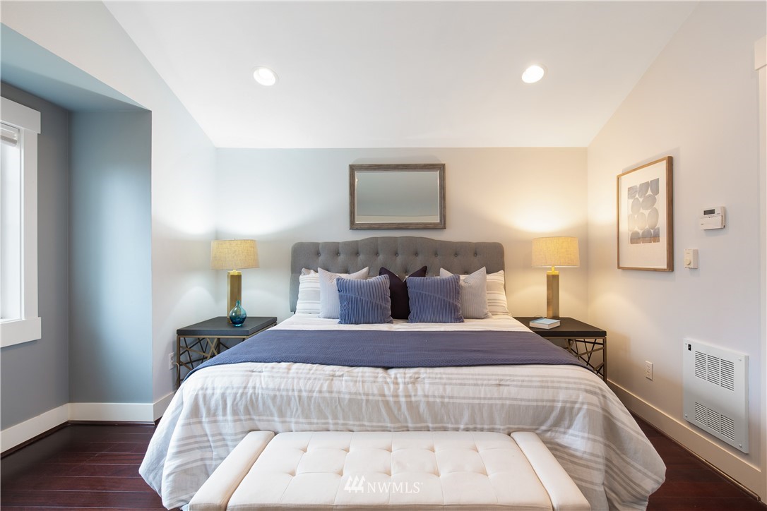 10303 Holman Road North, Unit A Seattle, WA 98177 - Photo 24 of 40 a bedroom with a bed and wooden floor